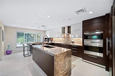 Kitchen featuring tasteful backsplash, wall chimne