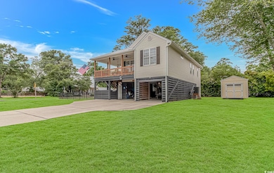 Rear view of property with stairs, a ceiling fan, a yard, a carport, and concrete driveway