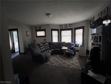 Carpeted living room featuring a textured ceiling