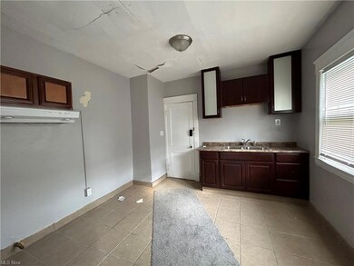 Kitchen with dark brown cabinets and light tile flooring