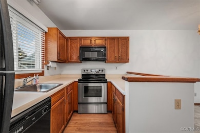 Kitchen with sink, black appliances, and light har