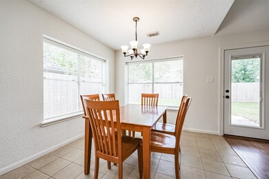 Enjoy your morning coffee or a casual meal in this sunlit space that's situated between the family room and the kitchen. It boasts a 5 light chandelier, durable tile floors, and a pair of corner windows with backyard views.