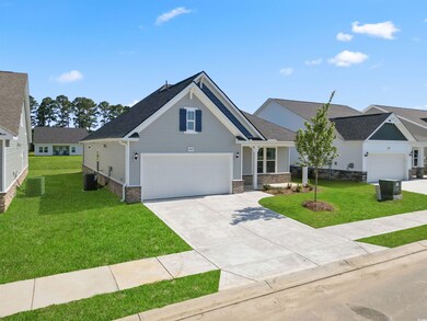 Craftsman-style home featuring a garage, a front yard, and central AC