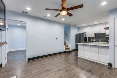 Kitchen with ceiling fan, tasteful backsplash, dark wood-type flooring, white cabinets, and recessed lighting