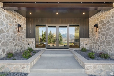 Doorway to property with stone siding, french doors, and a mountain view