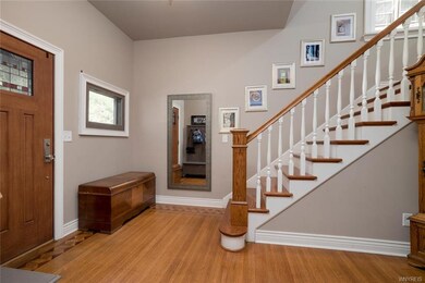 Large foyer with a beautiful new door and hardwood