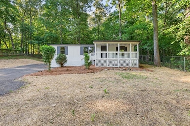 View of front of property featuring covered porch and view of scattered trees