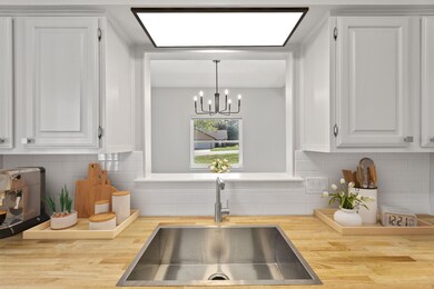 Room details with a sink, white cabinetry, a nota