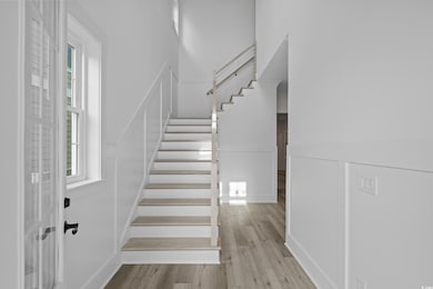 Stairway with wood finished floors and wainscoting