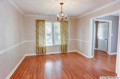 Enjoy entertaining and family meals in the formal dining room.  A designer light fixture, attractive laminate wood flooring, crown molding and chair rail trim all enhance this room.