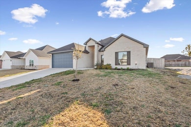 View of front of home with concrete driveway, a g