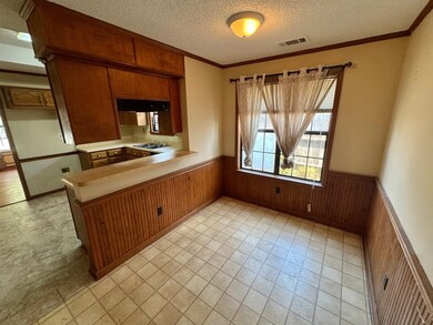 Kitchen featuring wood walls, crown molding, kitch
