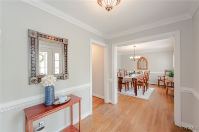 Hallway featuring baseboards, a notable chandelier