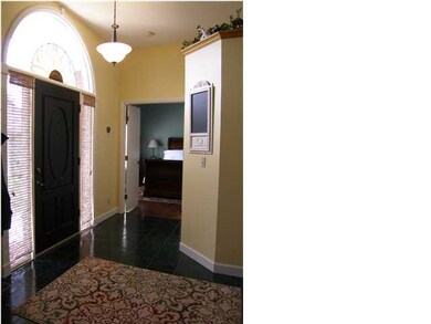 The roomy foyer features tile floor and tall ceili