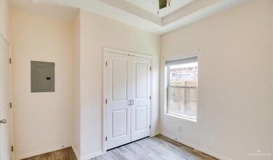 Unfurnished bedroom featuring light wood-style flooring, a closet, baseboards, and electric panel