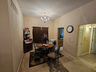 Carpeted dining area with a textured ceiling and a