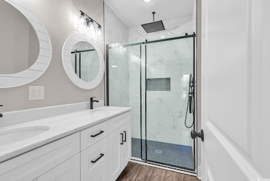 Full bathroom featuring double vanity, wood finish