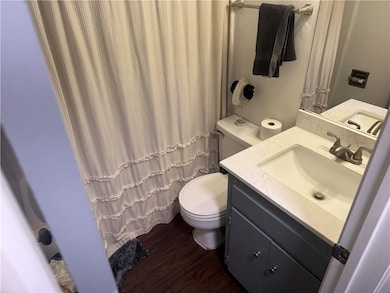 Full bath featuring toilet, wood finished floors,