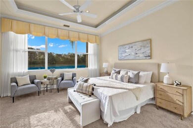 Carpeted bedroom with ceiling fan, a raised ceilin