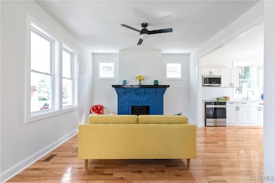 Living area featuring a fireplace, ceiling fan, an