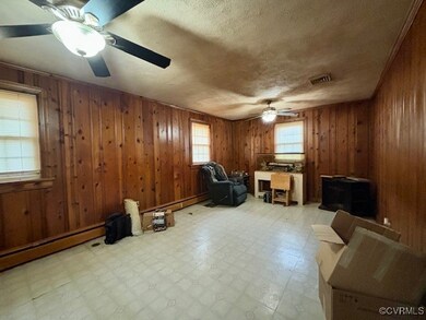 Office space with wood walls, ceiling fan, and a t