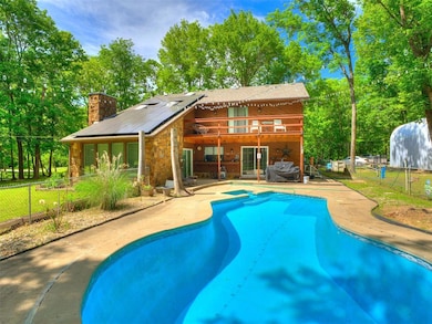 View of pool with a patio, fence, and view of scat