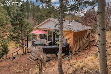 Back of house featuring a wooden deck, faux log si
