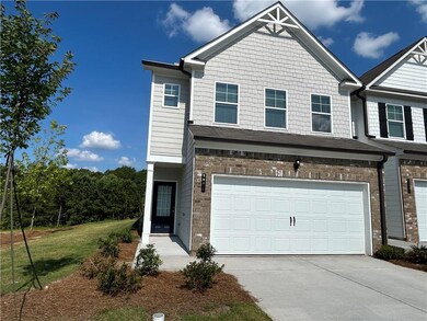 Multi unit property with driveway, an attached garage, brick siding, and a front lawn