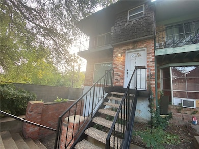 Entrance to property with mansard roof and brick siding