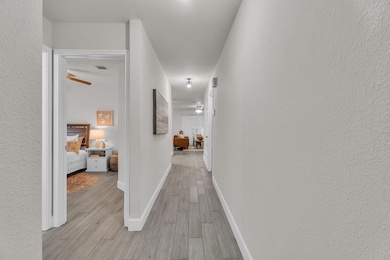 Hall with light wood-style flooring and baseboards