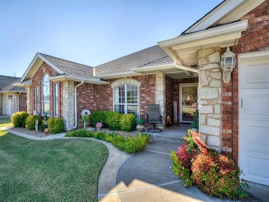 Entrance to property featuring brick siding, roof with shingles, a yard, and a garage