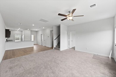 Living room featuring ceiling fan and light carpet