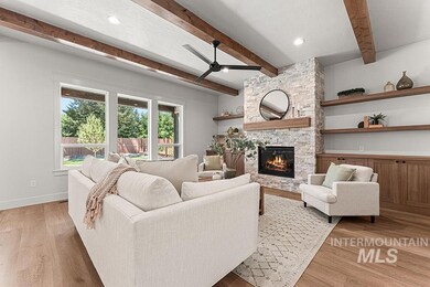 Living area with beam ceiling, a stone fireplace, light wood-style flooring, ceiling fan, and recessed lighting