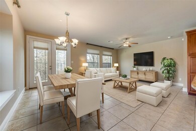 Virtually Staged- Tiled dining space/Living Room Area -featuring ceiling fan with notable chandelier