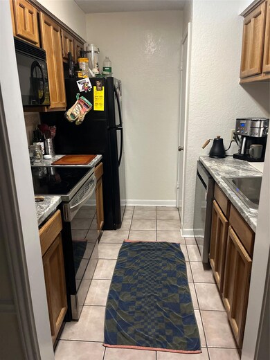 Kitchen featuring range, dishwasher, light tile p