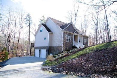 The first of 2 driveways leads to a large 2-car garage with high ceilings