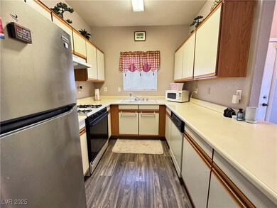 Kitchen featuring white appliances, dark wood-styl