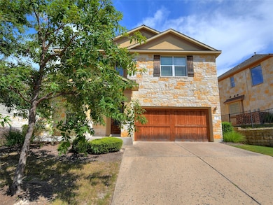 View of front of house with an attached garage, driveway, and stone siding