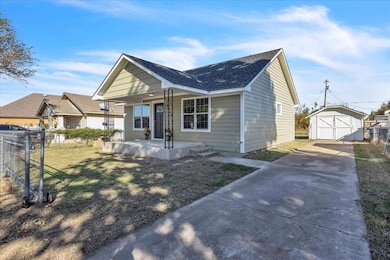 Bungalow-style house with covered porch, driveway, a shingled roof, an outbuilding, and a detached garage