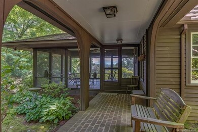 Covered breezeway with brick floor leads from the 