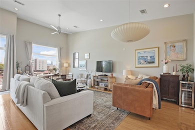 Living room with recessed lighting, beverage cooler, light wood-type flooring, and ceiling fan