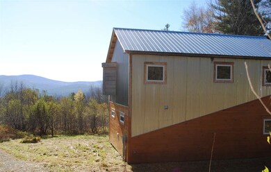 Home sits on sloping parcel surrounded by trees, a