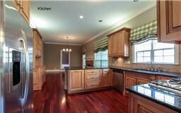 The home's gourmet kitchen has stainless steel appliances, granite countertops, custom wood cabinets, walk-in pantry and an adjoining large eating space for the family.
