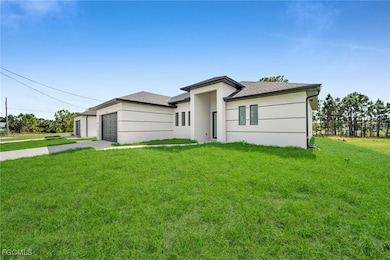 Prairie-style house featuring a front lawn, concrete driveway, a garage, and roof with shingles