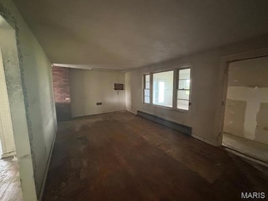 Unfurnished living room featuring a baseboard radiator