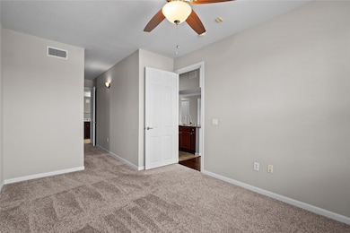 Primary Bedroom with plush carpet and direct access to the kitchen