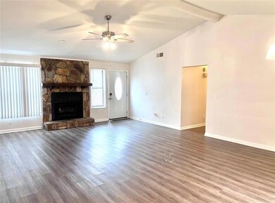Unfurnished living room with dark wood-style floors, a fireplace, and ceiling fan
