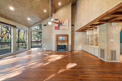 Unfurnished living room with hardwood / wood-style flooring, ceiling fan, beamed ceiling, and high vaulted ceiling