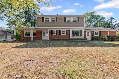 Colonial-style house featuring brick siding and a front lawn