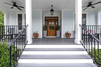 Entrance to property featuring ceiling fan and a porch